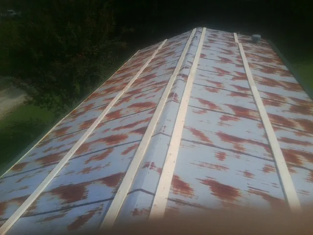 Rusted metal roof panels with new wood purlins before replacement — Storm Damage Roof Repair in Essex Junction by Roofing Brothers